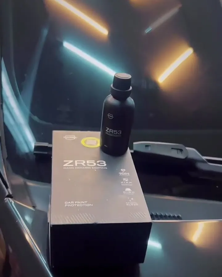 Frasco de vitrificador sobre o capô preto polido